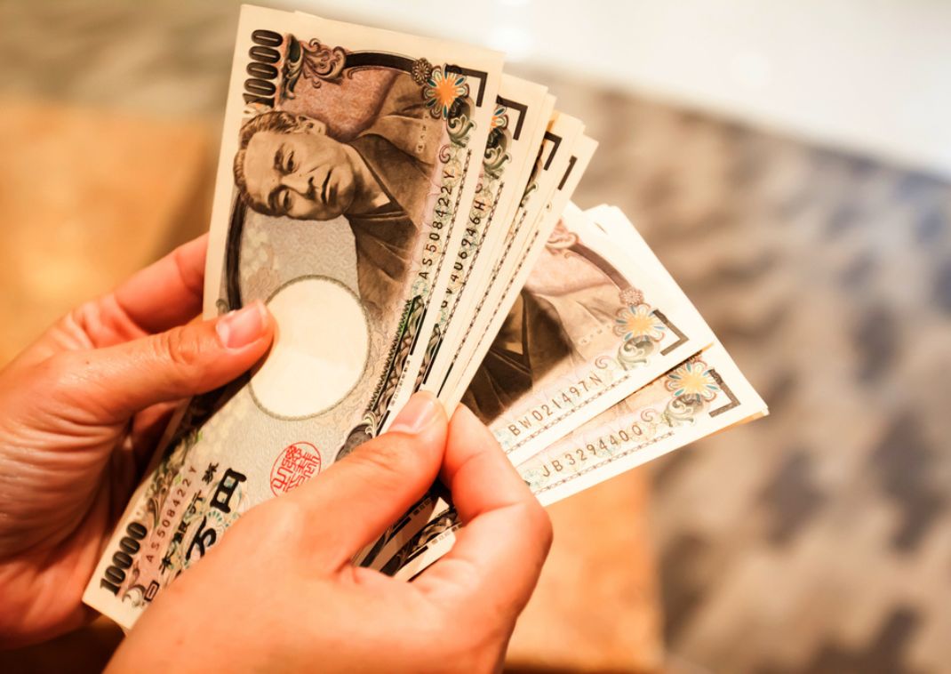 Person räknar japanska sedlar i yen