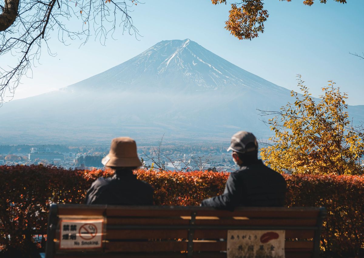 Ett par sitter på en bänk och njuter av utsikten över Mount Fuji