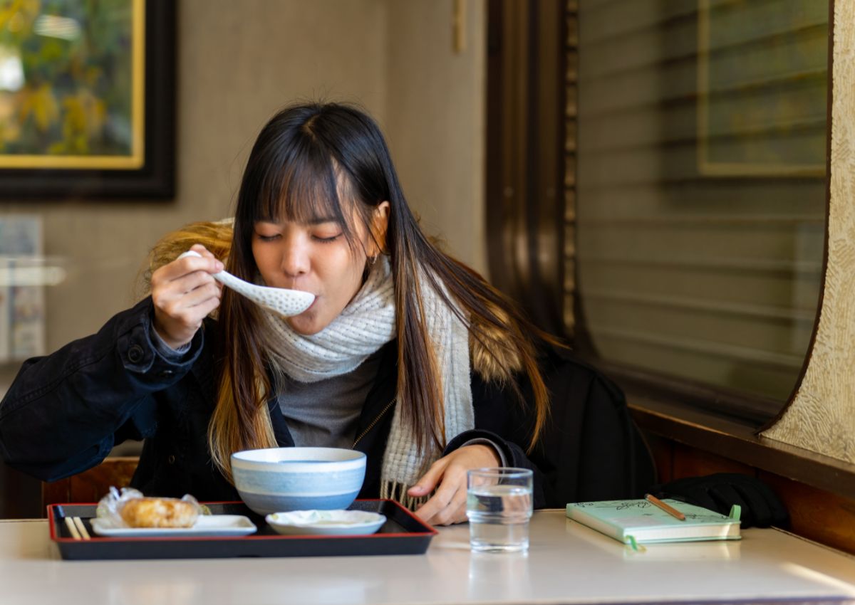 Kvinna som äter middag på japansk restaurang under vintern