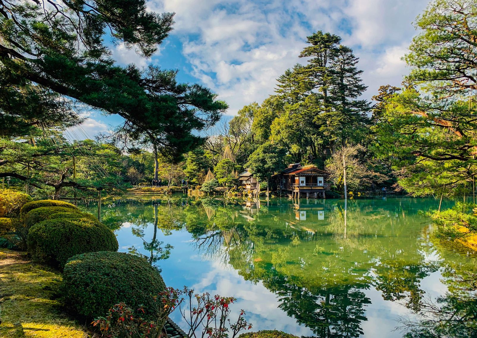 En blomstrande park med en sjö i mitten i staden Kanazawa, Japan.