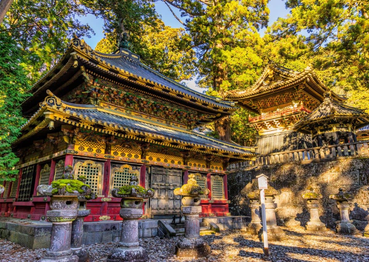 Nikko Toshogu helgedomen med sina karakteristiska gyllene dekorationer, omgiven av skog i Nikko, Japan.