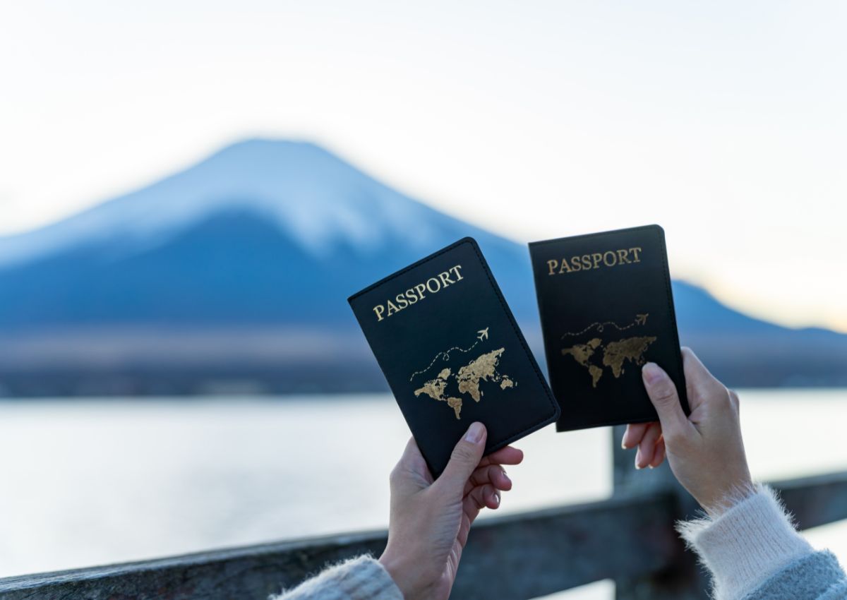 Ett pass hålls upp av kvinnliga händer framför det ikoniska Fuji-berget