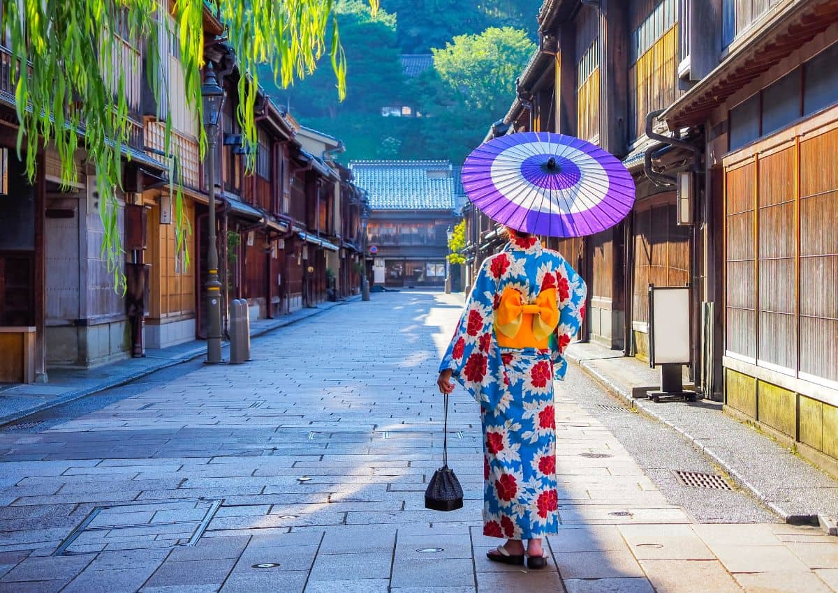 Kvinna i kimono promenerar genom Higashi Chaya District, Kanazawas historiska geishakvarter i Japan.