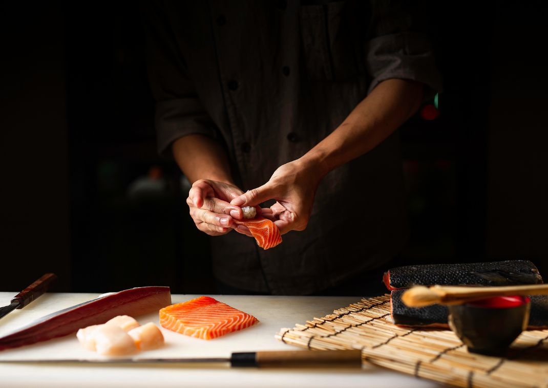 Japansk kock tillagar färsk sushi i Japan.
