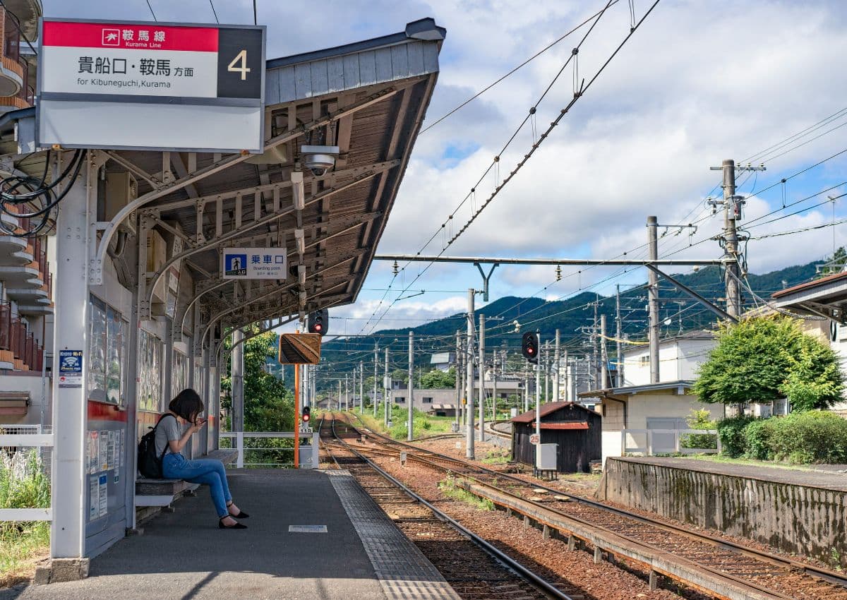 Kvinna väntar på ett försenat tåg på en station i Japan.