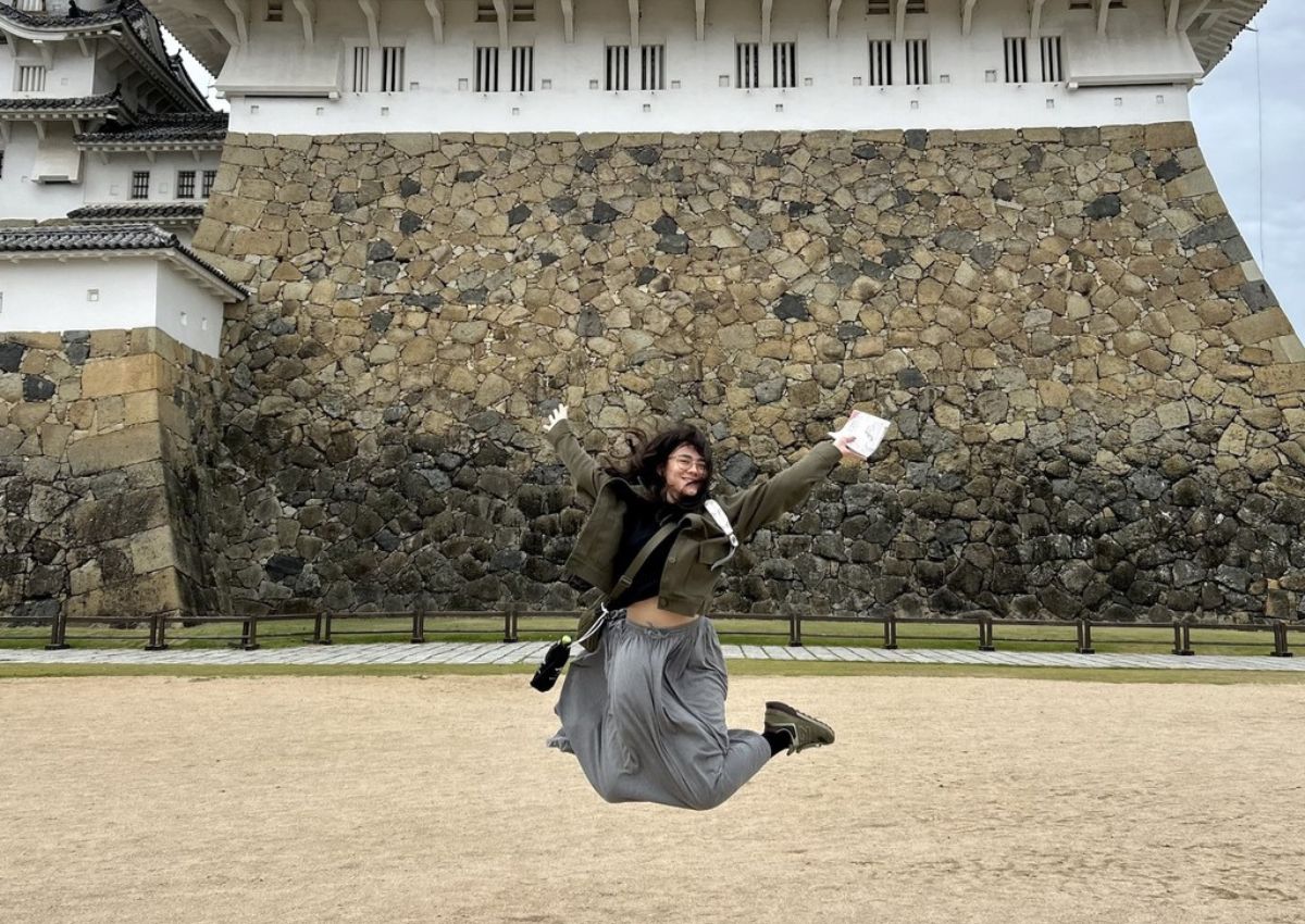 Ambre Taga framför det vita Himeji slottet i Japan.
