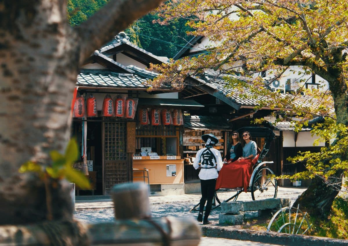 Två resenärer upplever Kyoto från en traditionell japansk rickshaw.