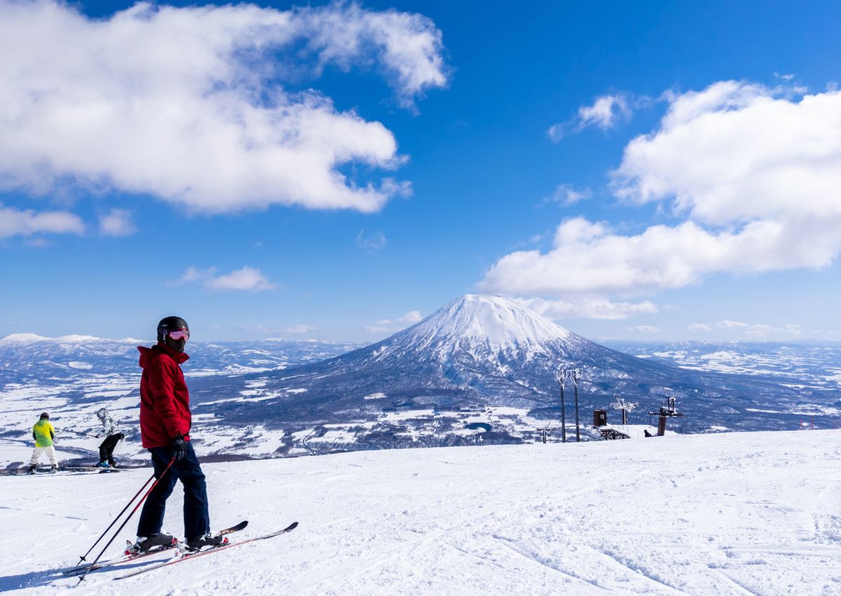 En kvinna som går i snö med sina skidor i Hokkaido