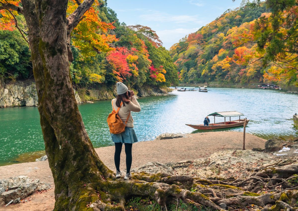 Resenär fotograferar höstfärgerna i Arashiyama i Kyoto.