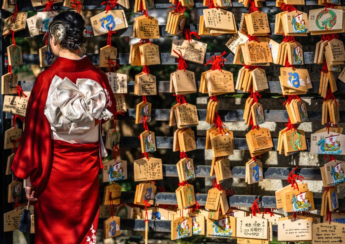 Kvinna i kimono vid en traditionell japansk helgedom.