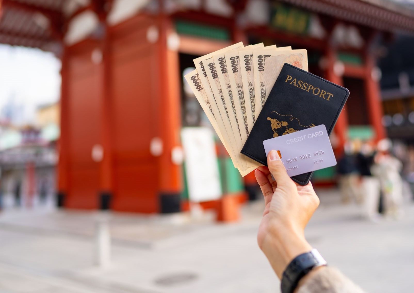 Kvinna håller pass, kontanter och bankkort framför Sensoji-templet, Tokyo, Japan