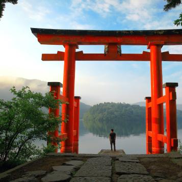Turist vid den röda torii-porten i Hakone Shrine, som ligger vid Ashi-sjön, Japan