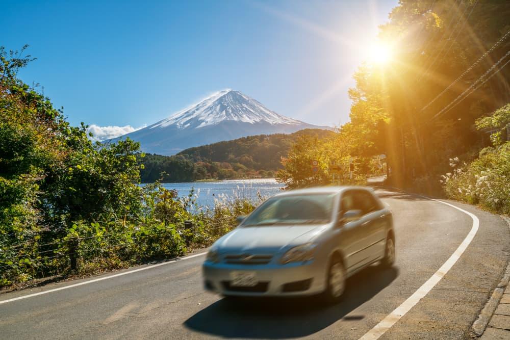 Bil kör nära Fuji-berget i Japan med rörelseoskärpa som visar snabb rörelse på en motorväg vid Kawaguchiko-sjön