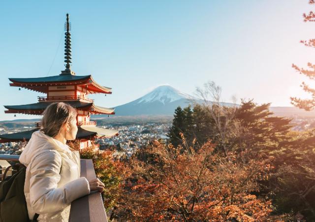 En kvinna blickar ut över berget Fuji med en pagoda bakom sig, Japan