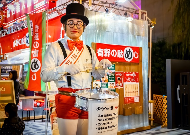 Underhållare uppträder på Dotonbori Street, Osaka