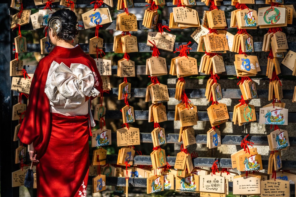 Japansk kvinna läser bönekort på en träplatta vid Kiyomizu-dera-templet i Kyoto