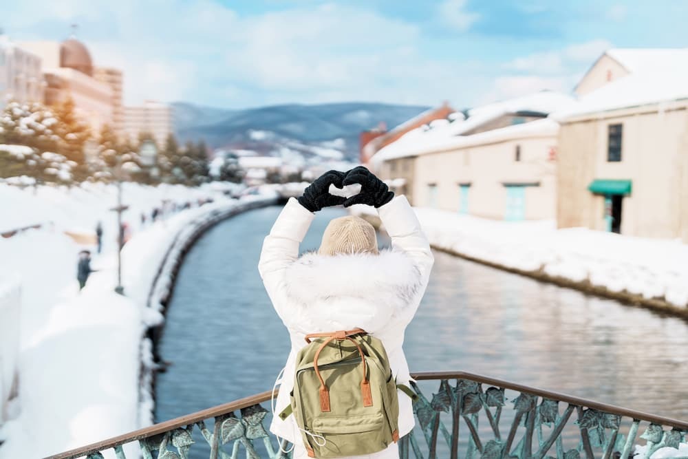 Turist på sightseeing längs den snöiga Otaru-kanalen i Hokkaido, Japan, njuter av vintersäsongen