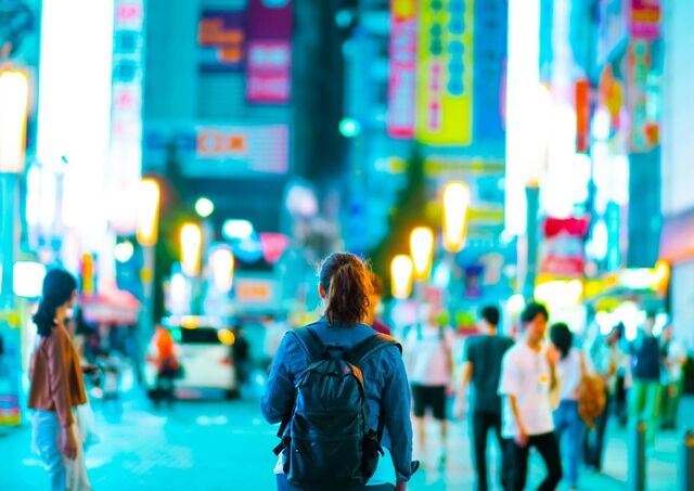  En flicka promenerar genom ett neonupplyst Tokyo.